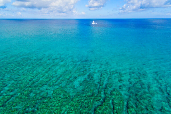 Spur and grove barrier reef features and yacht off of Grace Bay