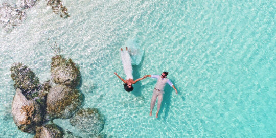 Bride and groom floating on Grace Bay