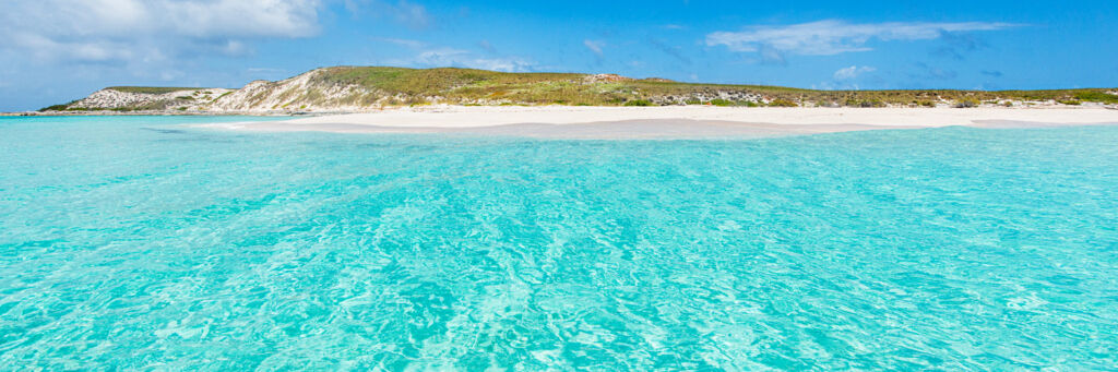 Turquoise and clear ocean water and the beach at Gibbs Cay