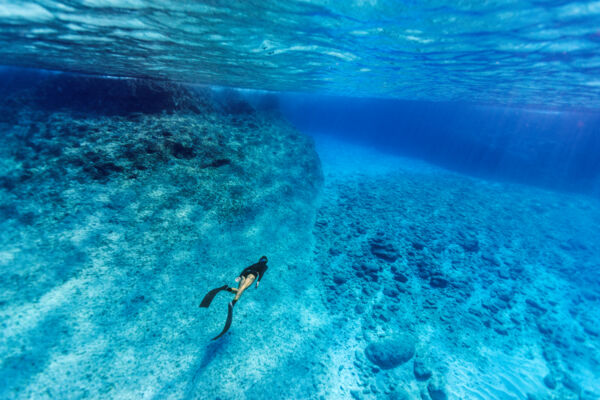 Freediving in the clear blue water off the cliffs of West Caicos